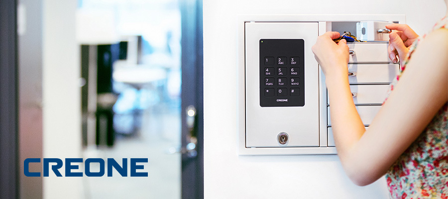 A woman puts keys in a Creone Key Cabinet