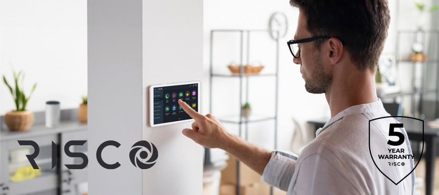 Man touching RISCO tablet on wall in house